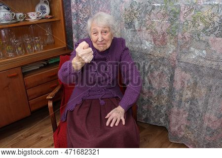 Stylish Elderly Woman Hipster With An Evil Face Shows A Fig. Concept Protest And Objection Of An Old