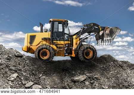 Bulldozer Or Loader Shovels Mountain Soil Into A Heap. Powerful Wheel Loader Or Bulldozer With A Lar