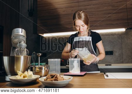 Female Confectioner Prepares Cream In The Kitchen