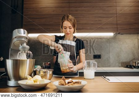 Beautiful Young Chef Decorating Delicious Dessert In Modern Kittchen
