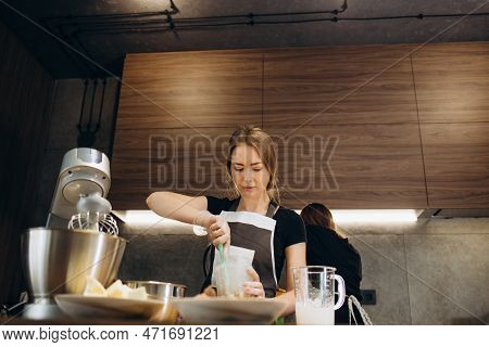 Beautiful Young Chef Decorating Delicious Dessert  In Modern Kittchen