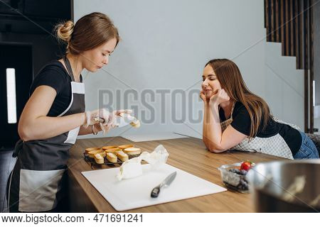 Beautiful Young Chef Decorating Delicious Dessert  In Modern Kittchen