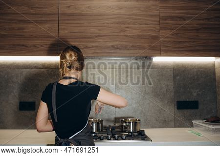 Beautiful Young Chef Decorating Delicious Dessert  In Modern Kittchen