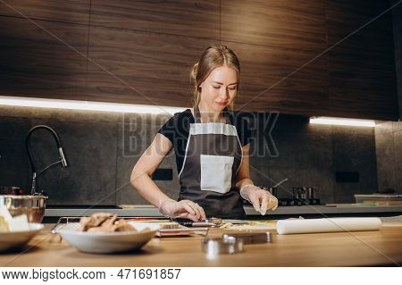 Beautiful Young Chef Decorating Delicious Dessert In Modern Kittchen