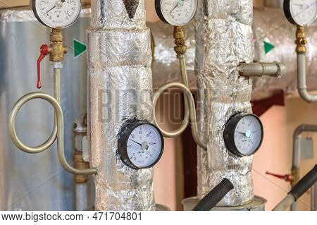 Plumbing Pipes With Pressure Gauges In The Basement Of A House