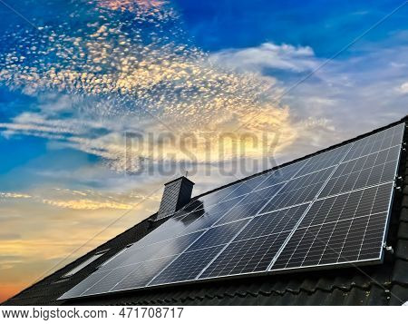 Colorful Sunset On Solar Panels Producing Clean Energy On A Roof Of A Residential House