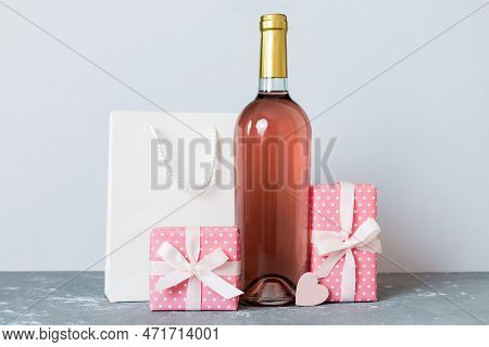 Bottle Of Wine On Colored Background For Valentine Day With Gift Box. Heart Shaped With Presrnt Box 