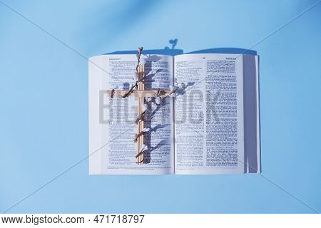 Cross Decorated Flowers With Open Holy Bible On Blue Background. Easter Holiday Minimalistic Concept