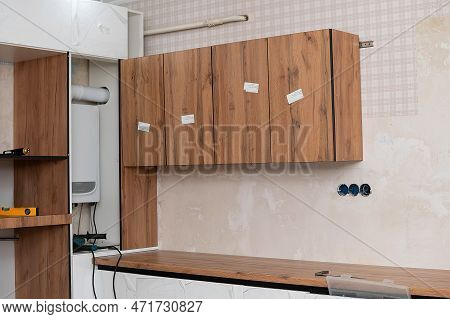 Installation And Installation Of A New Modern Kitchen In The House. Kitchen Cabinets In Various Stag