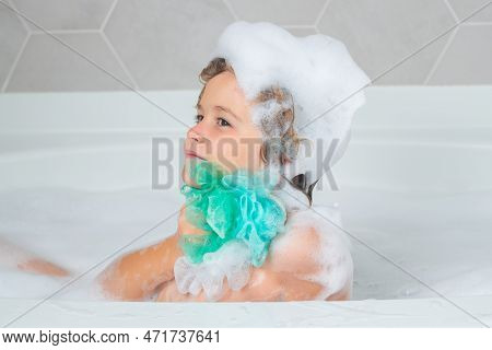 Child With Shampoo Foam And Bubbles On Hair Taking Bath. Funny Face Of Kid In Foam, Hair Care And Hy
