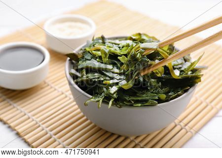Fresh Laminaria (kelp) Seaweed In Bowl And Chopsticks On White Table