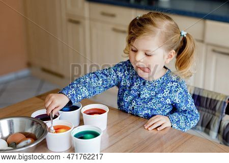 Excited Little Toddler Girl Coloring Eggs For Easter. Cute Happy Child Looking Surprised At Colorful