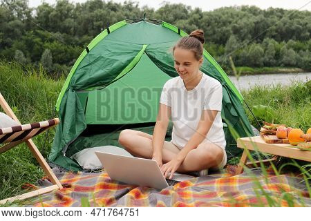 Image Of Caucasian Woman With Bun Hairstyle Wearing White T Shirt Sitting Near The Tent Near The Riv
