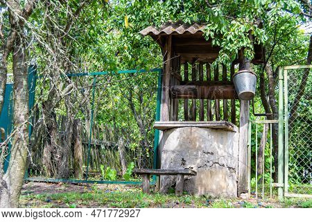 Old Well With Iron Bucket On Long Forged Chain For Clean Drinking Water