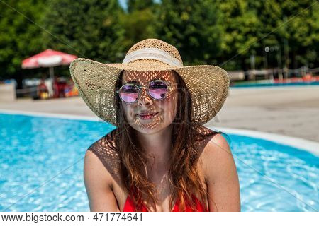 Young Beautiful Woman With Hat And Red Swimsuit Relaxing In The Hydromassage Of Swimming Pool. Conce