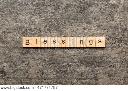 Blessings Word Written On Wood Block. Blessings Text On Cement Table For Your Desing, Top View Conce