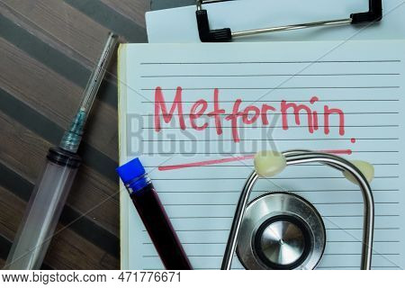 Concept Of Metformin Write On Book With Stethoscope Isolated On Wooden Table.