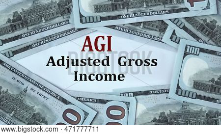 Agi (adjusted Gross Income) - Acronym On The Background Of Cash Dollar Bills. Concept Of Economic Gr