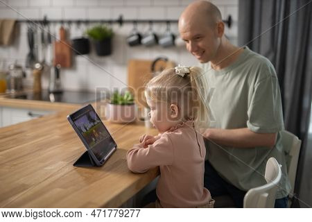 People With Cochlear Implant System. Kid Study To Hear With Her Father, Learning With Video On Table