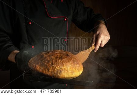 Professional Baker Bakes Bread On A Sheet Pan In Bakery. Scraper In The Chef Hand. Place For Menu Or