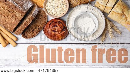 Different Baked Gluten Free Products And Text On White Wooden Table, Top View