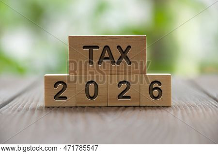 Tax 2026 Text On Wooded Blocks With Blurred Nature Background. Taxation And Filing Concept.