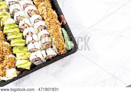 Pre-packaged Variety Of Sushi And Sushi Rolls In A Plastic Tray.