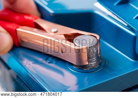 Connection Of Clamp To The Positive Terminal Of A Car Lead-acid Battery, Close Up. Charging Auto, Br