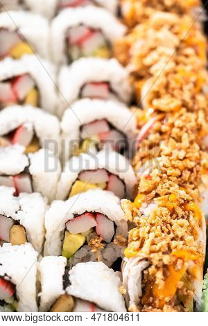 Pre-packaged Variety Of Sushi And Sushi Rolls In A Plastic Tray.