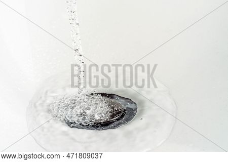 A Stream Of Clean Water Pours Into The White Sink. Selective Focus.
