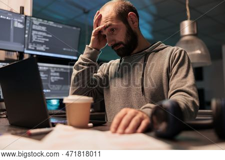 Stressed Overworked Developer Programming Html Code On Laptop And Multiple Monitors, Working Under S