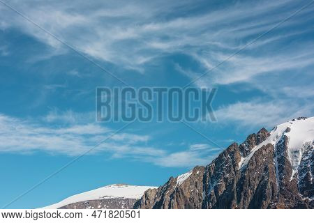 Scenic Alpine Landscape With Snowy Mountain Tops Under Cirrus Clouds. Awesome Landscape With Rocky P