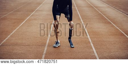 A Tired Unknown Runner With Artificial Leg Standing On Running Track At Stadium And Taking A Break.