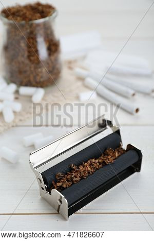 Roller With Tobacco On White Wooden Table. Making Hand Rolled Cigarettes