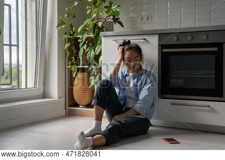 Upset Depressed Asian Girl Suffering From Breakup, Heartbroken Frustrated Woman Sits On Floor In Kit