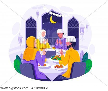 A Muslim Family Praying Before Having Iftar To Break Fasting During Ramadan. Food And Dates On The T