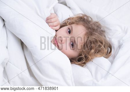 Kid Under Covers, Face Cover With Blanket. Quietly Sleeping. Portrait Of Little Child Lying On Big B