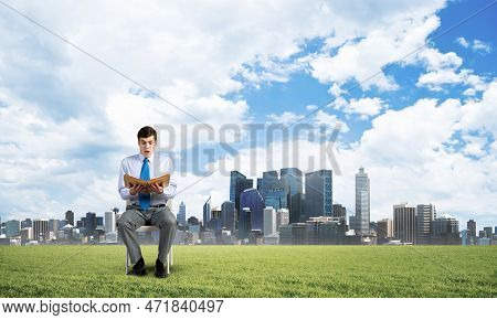 Young Businessman With Book On Office Chair