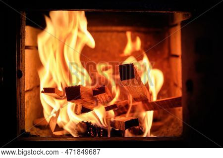 Burning Logs And Ashes Inside A Wood-burning Fireplace On Black Background, Close Up On Flames