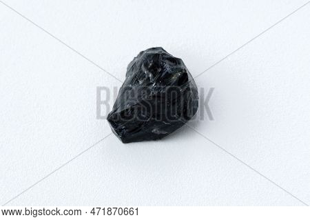Black Obsidian Stone On A White Background. Natural Glass. Black Mineral Gem