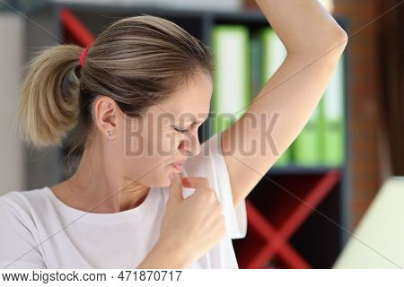 Portrait Of Young Female Sniffing Armpits And Feeling Of Revulsion Because Of Smell. Hygiene And Hea