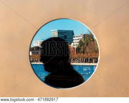 Zug, Switzerland - December 31, 2021: A View Through The Round Opening At The Promenade Of Zug In Sw