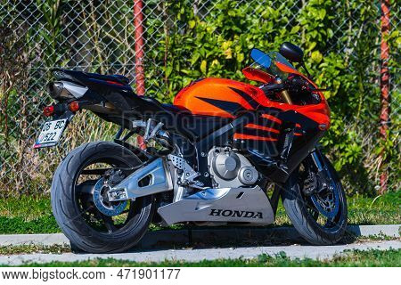 Side, Turkey -january 23, 2023:    A  Black Motorcycle Stands In A Parking Against The Backdrop Of S