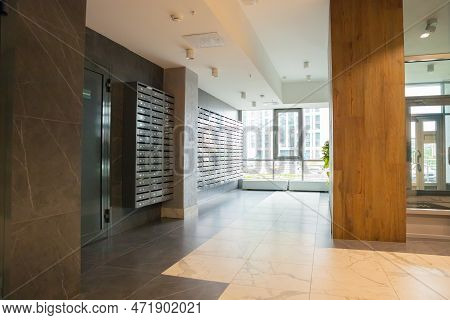 Hall Of Modern Multifamily Building. Entrance, Metal Mailboxes A Lot. Multistory Residential Buildin