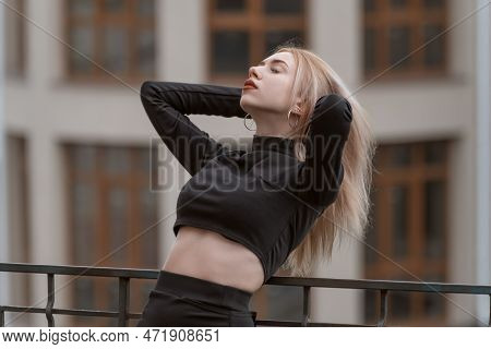 Portrait Of Young Attractive Woman In Black Short Top Threw Her Head Back And Adjusts Her Hair. Girl
