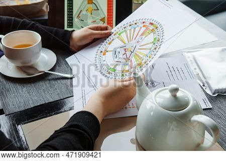 Tver, Russia - February 12, 2023: A Woman At The Table Is Studying A Rave Mandala By Human Design. R