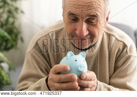 Senior Man Holding Piggy Bank. Financial Security Planning Concept. Economy And Saving.
