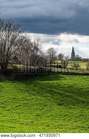 View Over The Green Fields And Meadows With The Village Of Ossel In The Background, Merchtem, Belgiu