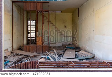 Interior Of An Old Abandoned House Kitchen With Damaged Furniture And A Messy Floor.