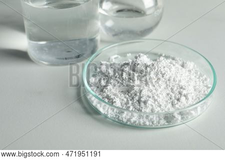 Petri Dish With Calcium Carbonate Powder And Laboratory Glassware On White Table